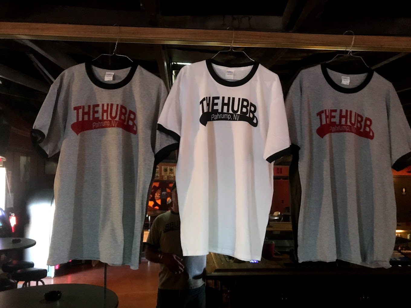Printed grey and white tees on hangers reading The Hubb, made at the Hubbster shop
